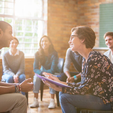 multiple people sitting in a circle, support group